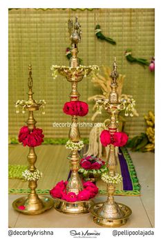 three metal candlesticks with flowers on them