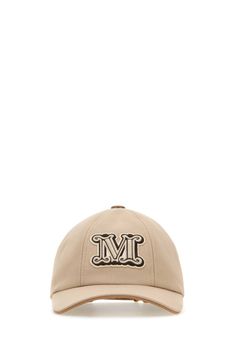 a beige baseball cap with the m logo on it, and an embroidered monogram