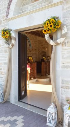 the sunflowers are hanging from the doorway to decorate it with ribbons and bows