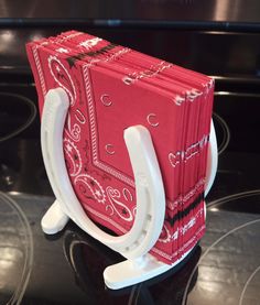 a red and white book holder sitting on top of a stove