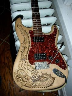 an electric guitar with dragon carvings on it