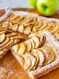 sliced apple pie sitting on top of a wooden cutting board