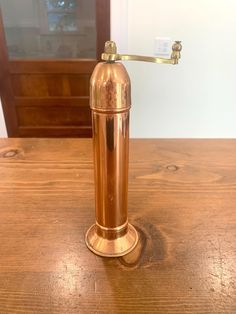 an old fashioned copper water dispenser on a wooden table