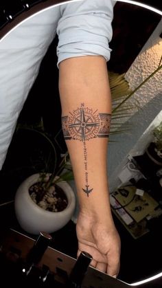 a person with a compass tattoo on their arm