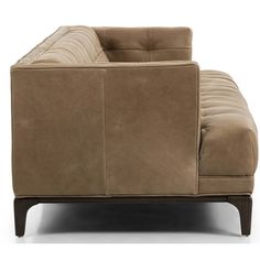 a tan couch sitting on top of a white floor