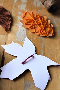 the paper leaves are cut out to look like an autumn leaf with string on it