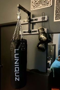 a black punching bag hanging from the side of a wall next to a mirror in a bedroom