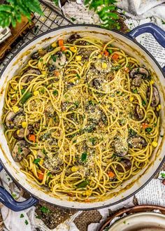 pasta with mushrooms and parmesan cheese in a skillet on top of a table