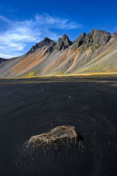 a black sand beach with mountains in the background