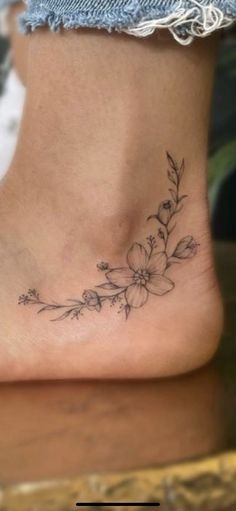 a woman's foot with a flower tattoo on it