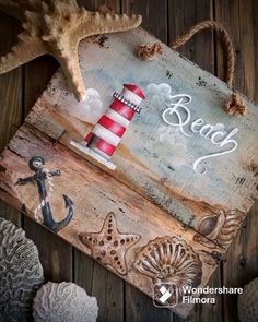 a wooden sign with an anchor, starfish and lighthouse on it