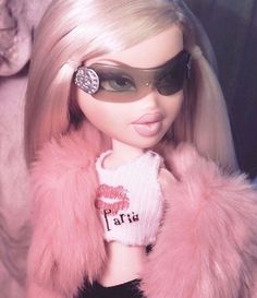 a close up of a barbie doll wearing sunglasses and a pink fur coat with an eye patch