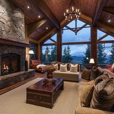 a living room with couches and a fire place in the center is lit by lamps