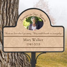 a wooden sign with an image of mary walker on it and a tree in the background