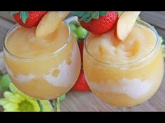 two glasses filled with fruit sitting on top of a table