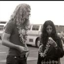 two women standing next to each other in a parking lot