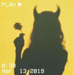 the shadow of a person holding a flower in front of a yellow background with text that reads play 8 28 mar 2013