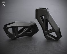 two metal objects sitting side by side on a table with black background and grey flooring