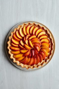 a pie with sliced peaches in it on a plate