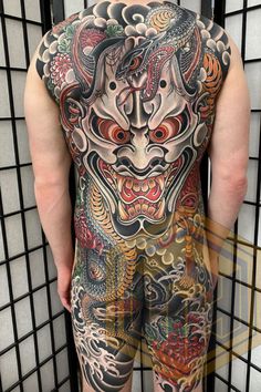 the back of a man's body with tattoos on it and dragon tattoo designs