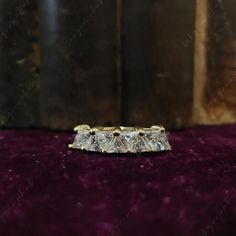 a diamond ring sitting on top of a velvet surface