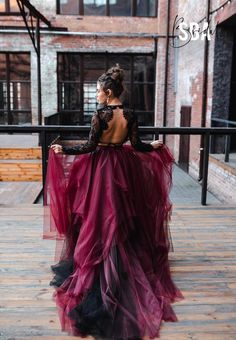 a woman in a long purple dress is sitting on a balcony with her back to the camera