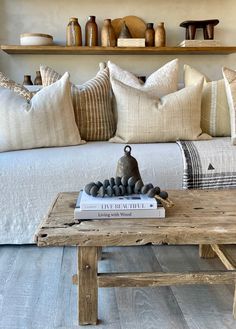 a living room filled with lots of furniture and pillows on top of a wooden table