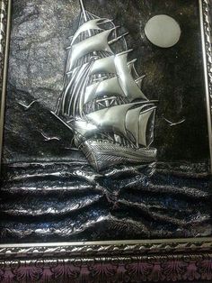 a silver plate with a ship on it and the moon in the sky behind it