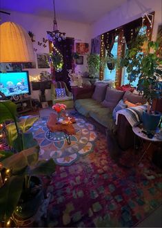 a living room filled with furniture and lots of plants on the wall next to a flat screen tv