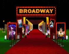 the entrance to broadway is lit up at night with red carpet and lights on it