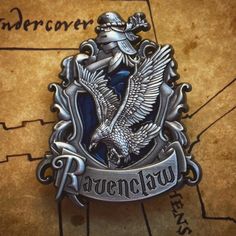 the ravenclaw crest is on top of a map with an eagle flying over it