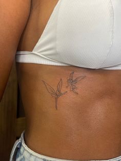 a woman's stomach with a humming tattoo on it