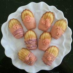 some kind of dessert on a white plate with pink icing and rose decorations around it