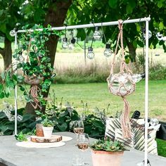 an outdoor table set up with wine glasses and plates