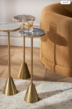 two small tables with gold bases on a rug