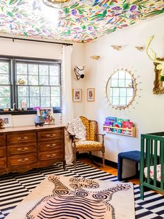 a baby's room with a crib, dresser, and mirror in it