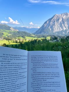 an open book sitting on top of a lush green field