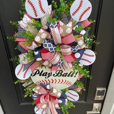 a baseball wreath with the word play ball hanging from it's side on a door