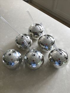 four shiny silver balls sitting on top of a counter