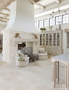 a living room filled with furniture and a fire place in the middle of an open floor plan