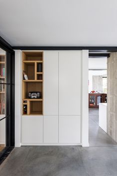 an open book shelf in the middle of a room with white walls and flooring