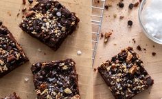 chocolate brownies with nuts and sea salt on a cutting board next to a glass of milk