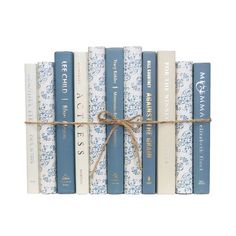 the blue and white books are tied with a brown ribbon on top of each book