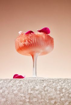 a mushroom like structure with pink flowers on it's head and two petals at the base