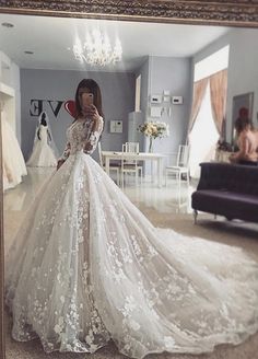 a woman taking a selfie in front of a mirror wearing a white wedding dress