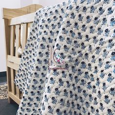 a blue and white blanket sitting on top of a wooden bench next to a wall