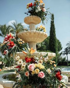 three tiered fountain with flowers and greenery