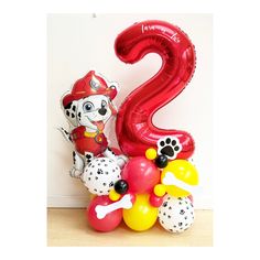 the balloon is shaped like a number two and has paw patrol characters on it, along with other balloons