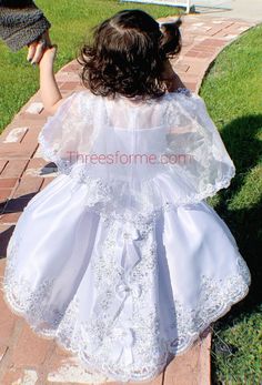 "Our Virgin Mary Embroidered Baptism Collection is here! All our dresses are made here in the United States. A 3 pcs dress: includes dress, cape and headband. Our dresses are made of satin, organza and tull. We use satin on our beautiful dresses and organza on capes. Corset on both sides to adjust for perfect fit. A large Virgin Mary Embroidery on chest of dress. Translucent chest top. Dress is high-low cut which means dress has a train on back with beautiful bows. Cape is button attached. fresh Bautizo Ideas Girl Dress, Virgin Mary Embroidery, Mary Embroidery, Bautizo Ideas, Baby Baptism Dress, Baptism Dress Baby Girl, Dress Cape, Baptism Gown