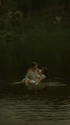 a man and woman are in the water on their backs, one is holding the other's head